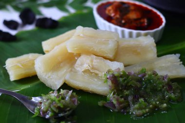 Kaynamış tapyoka, muz yaprağında servis edilen kappa baharatlı yeşil biber sosu ve canlı Kerala stili kırmızı balık körisi, meen köri. Geleneksel yemek için mükemmel bir Güney Hint yemeği.