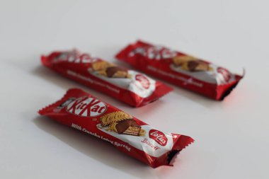 Mumbai, Hindistan, 15 Mayıs 2024: Çıtır Nilüfer Bisküvisi 'nin kırmızı ambalajlarla kaplandığı KitKat barları, bisküvi-çikolata tasvirleri. Rahatlık ve nostalji teması için ideal atıştırmalıkları temsil eder.