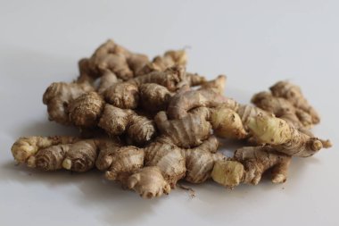 Doğal bir yığın içinde taze zencefil kökleri, kabuklu dokuları ve soyulmuş sarımsı derisi. Hint mutfağını ve şifasını temsil eder. Refah, özgünlük ve aşçılık mirası teması için idealdir.