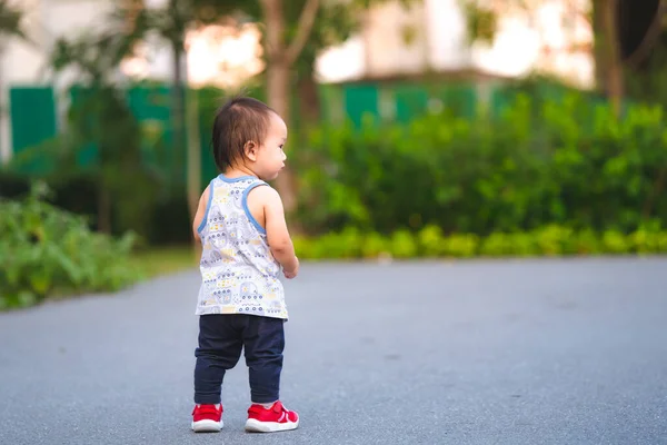 小孩站在公园里 一个一岁的小孩在学走路 进入案文的空白处 — 图库照片