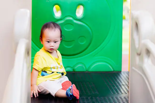 놀이터 장비에 앉아있는 아시아 소년의 초상화 여름이나 시간에 아이는 날씨로 스톡 사진