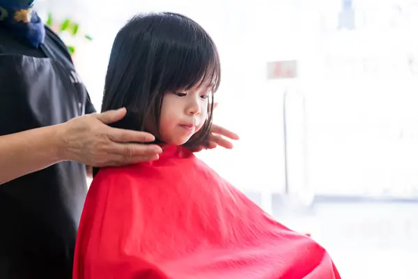 Die Hände Eines Friseurs Stylen Ein Kleines Asiatisches Mädchenhaar Nachdem Stockbild