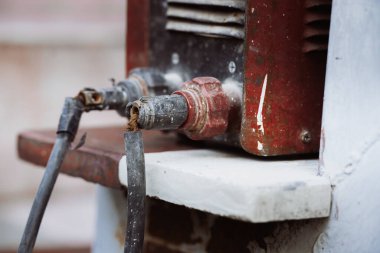 Kaynak kablosunun kablosu zarar görmüş, kırmızı ve altın iletkenler görünür, tehlikeli, standartların altında teknisyen işi güvenli değil.
