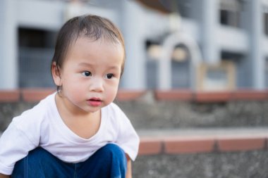 Akşamları oturup oynayan küçük bir çocuğun yakınlaşması. Tatlı çocuğun ağzı sulanıyordu, gözleri yaşlarla doluyordu. Asyalı çocuklar, 1,5 yaşında..