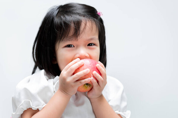 Crunchy Delight Adorable Asian Girl Enjoys Juicy Red Apple Clean Stock Picture
