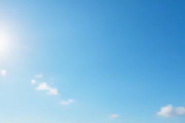 Gökyüzü Arkaplanı. Minimum beyaz bulutlar ve güneşin pırıl pırıl parlaklığıyla noktalanan berrak mavi gökyüzü. Arka plan için mükemmel, biraz sakinlik ve iyimserlik katıyor..
