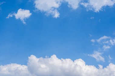 Pofuduk beyaz bulutlarla dolu parlak mavi gökyüzü güneşli bir günde. Doğa Arkaplanı.