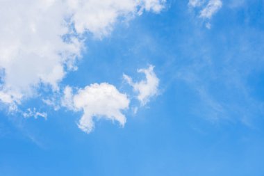 Pofuduk beyaz bulutlarla dolu parlak mavi bir gökyüzü, uzun kulaklı tavşan şeklinde bulutlar, güneşli bir günde mutlu bir şekilde zıplayan çocukluk hayalgücü..