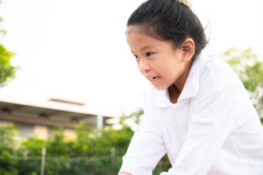 Asyalı bir kızın tırmanma ipiyle oynaması ve heyecan göstermesi..