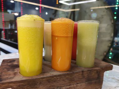 Selective focus of Set of tropical fruit juices in glasses at a restaurant.
