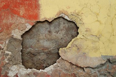 Eski, eski, desenli arka plan, eski alçıyla kaplı, çatlamış, soyulmuş, ortasında bir delik olan duvar, klasik şehir tarzı.                  