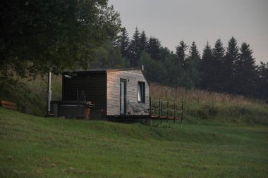 Saunası ve köpük banyosu olan bir modül evi ya da ormandaki dağ tepe arka planlı bir jakuzi. Sakin atmosfer
