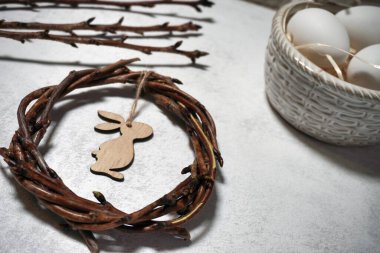 the easter wreath from branches vines with bunny on grey background with copyspace. decoration branches with buds and pussy willow and eggs