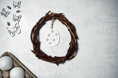 Üzüm dallarından kopyalanmış gri arkaplanda iplik olan paskalya çelengi. Yumurtalarla süsleme