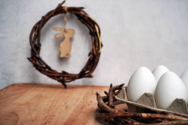 Üzüm dallarından kopyalanmış gri arkaplanda iplik olan paskalya çelengi. Yumurtalarla süsleme