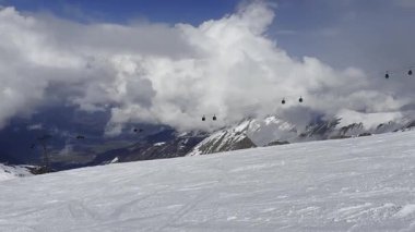 Kaprun, Alplerdeki modern kablo kabini dağlarda hareket ediyor, kış kayak sezonu. Kısmen mavi gökyüzü ve arka planda bulutlu