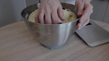 Paskalya yemeği için hamur mayası yapan bir kadın. Kuru üzüm, un, tereyağı. Süslenmek için yumurta içinde çiçekler. Geleneksel fırın