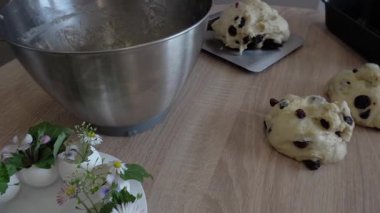 Paskalya yemeği için hamur mayası yapan bir kadın. Kuru üzüm, un, tereyağı. Süslenmek için yumurta içinde çiçekler. Geleneksel fırın