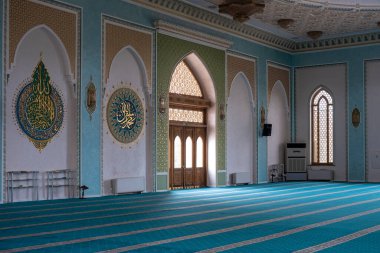 Mozaikli ve desenli geleneksel yeşil halıları olan bir cami.