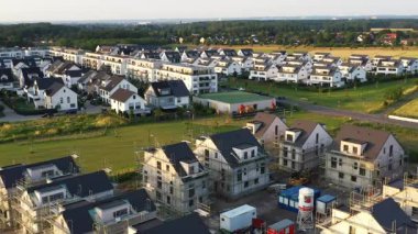 Birçok Modern Ayrılmış Ev ve Apartman Binası ve Kırsal Bölgede Yapı Yapımı Yapılmakta Olan Ayrılmış Evleri olan Bir İnşaat Alanı ile Bir Konutun Üstünden Geçiş.