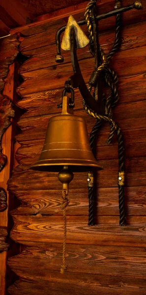 metal bell on a wooden background. on a sea vessel. A warning bell on deck.
