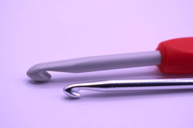 Açık renkli arka planda bir dikiş malzemesi. Tığ işi kancası. Hobi. 