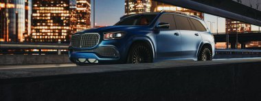 Araba tarafı, lüks, koyu mavi renkli, yolda, şehirde, arka planda, birçok ışığı olan büyük şehir. ve gayrimenkul binaları, 3D tasarım ve resimleme