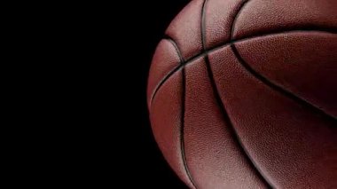Temiz bir siyah arka planda, pürüzsüz bir döngüde dönen bir basketbol topunun 3 boyutlu animasyonu. Detaylı dokuya sahip yüksek kaliteli görüntüleme, spor tanıtımları, markalaşma ve hareket grafikleri için mükemmel.