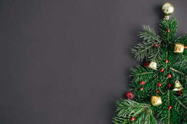 Mutlu Noeller! Köknar dallarından, kırmızı böğürtlenlerden ve siyah arkaplandaki altın takılardan yapılmış şık bir Noel ağacı. Yaratıcı fikir, kış tatili. Modern festival düzlüğü, metin için boşluk