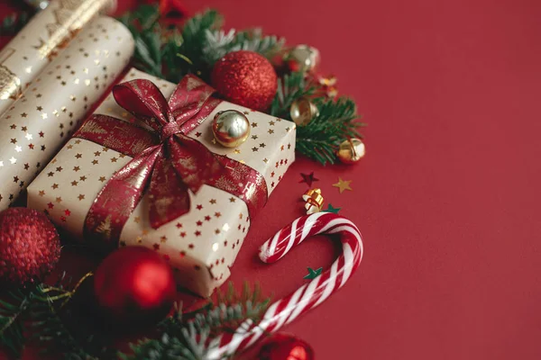 圣诞快乐 节日快乐 现代圣诞节的作品 时尚的圣诞礼物 包装纸 冷杉枝条 红色背景的甘蔗和灌木 复制空间 喜庆横幅 — 图库照片