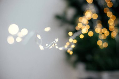 Modaya uygun Noel ışıkları karamsar arka planda kapanıyor. Ilık altın ışıklı bokeh ve çelenk ışığı yaklaş. Mutlu Noeller ve mutlu yıllar! Atmosferik kış zamanı, tatil dekorasyonu
