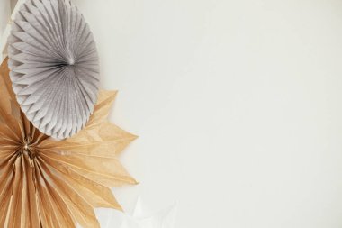 Beyaz duvar arkasında asılı şık kağıt noel yıldızları. Boho odasında modern şenlik dekorasyonu, metin için yer. El yapımı kağıt İsveç yıldızları. Atmosferik Noel dekorasyonu