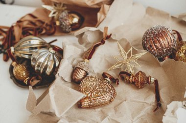 Merry Christmas! Stylish vintage christmas ornaments on craft paper. Golden baubles, ribbons and scissors festive still life. Moody aesthetic banner. Preparation for holidays, atmospheric time