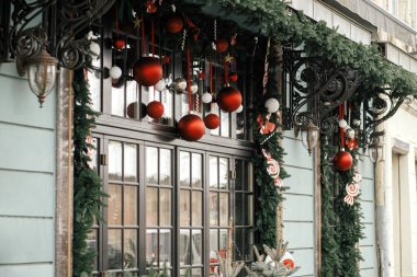 Şık noel köknar dalları ve dış binalarda kırmızı mücevherler. Şehir caddesinde modern noel dekorasyonu. Avrupa 'da kış tatili. Mutlu Noeller.