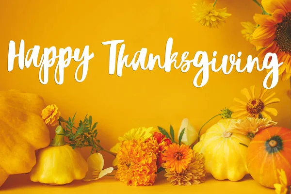 Happy Thanksgiving greeting card. Happy Thanksgiving text and colorful flowers, pumpkin, squashes modern composition on yellow background. Handwritten lettering