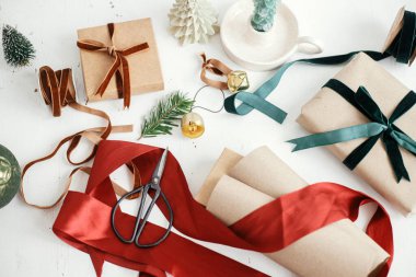 Şık noel hediyelerini paketlemek düzdü. Modern noel hediyesi kutusu, kurdeleler, el işi kağıt ve beyaz ahşap üzerine süslemeler. Mutlu Noeller ve mutlu tatiller! Estetik kış tatili