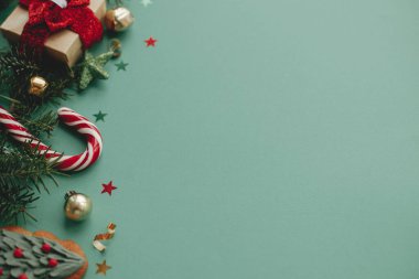Mutlu Noeller! Modern Noel afişi. Şenlikli süslemeler, konfetiler, köknar dalları, yeşil arka planda hediyeler. Mevsimler tebrik kartı şablonu, metin için boşluk