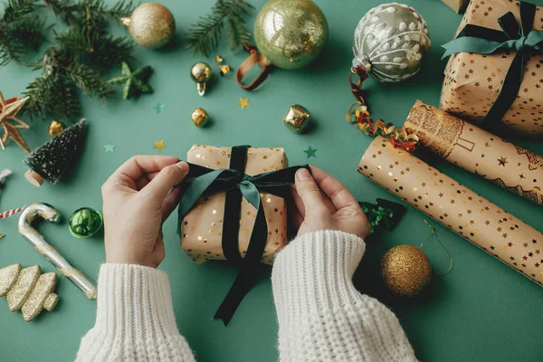 크리스마스 손으로 아름다운 크리스마스 황금색 포장지 그리고 배경의 장식을 포장한다 — 스톡 사진