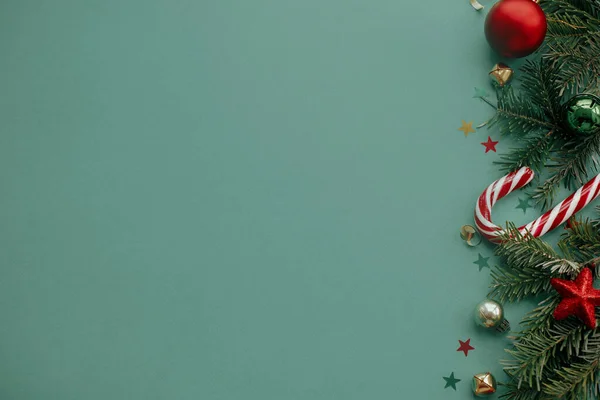 メリークリスマス 緑の背景にお祝いの装飾 コンフェッティ モミの枝とスタイリッシュなクリスマスの境界線 クリスマスフラットレイ 季節の挨拶カードテンプレート テキストのためのスペース — ストック写真
