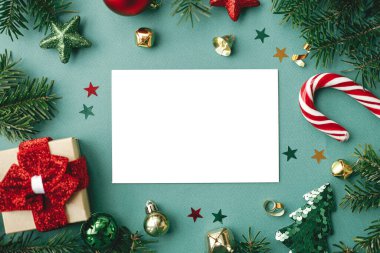 Christmas card flat lay. Modern greeting card mock up with stylish christmas decorations and ornaments on green background. Empty postcard template, space for text. Merry Christmas