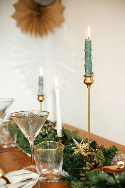 别致的圣诞餐桌布置 餐盘上有铃铛 老式餐具 有金光的冷杉枝条 桌上有蜡烛 大气假日早午餐 — 图库照片