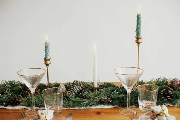 クリスマステーブルのセッティング 皿の上に鐘を持つリネンナプキン ヴィンテージカトラリー テーブルの上に黄金のライトと松のコーンとモミの枝 テーブルの休日の配置 — ストック写真