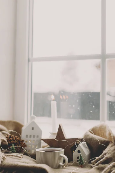 一杯热茶 小圣诞节的房子和树 木制的星星在舒适的毛毯上的窗台上 冬天的土拨鼠大气圣诞背景 下大雪的时候舒服的回家 — 图库照片