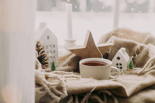 冬天的土拨鼠一杯热茶 小圣诞节的房子和树 木制的星星在舒适的毛毯上的窗台上 舒适的家 大气下雪天 圣诞节背景 — 图库照片