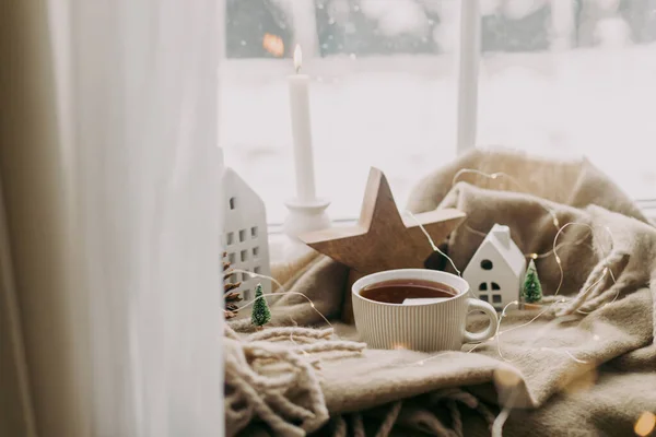 下雪天舒适地回家 一杯热茶 小圣诞节的房子和树 木制的星星在舒适的毛毯上的窗台上 冬天的土拨鼠大气丑闻和鸟类情绪 — 图库照片