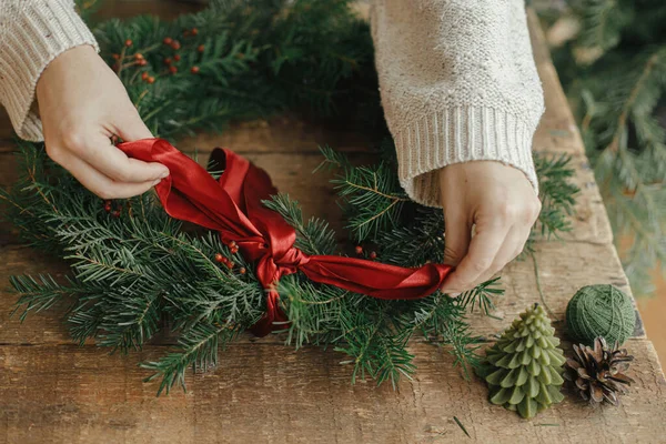 크리스마스 화환만들기 크리스마스 트리를 장식하고 손에는 소나무 원추형 양초가 리본이 — 스톡 사진
