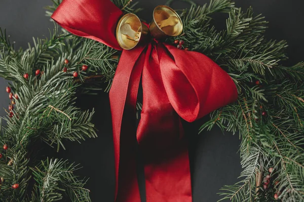 Grinalda Natal Elegante Com Fita Vermelha Sinos Dourados Fundo Escuro — Fotografia de Stock