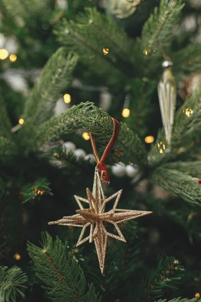 ヴィンテージスターと黄金のライトが閉じられている赤ちゃんとクリスマスツリー お祝いの部屋でスタイリッシュな装飾が施されたモダンなクリスマスツリーの枝 冬休み 大気時間 — ストック写真
