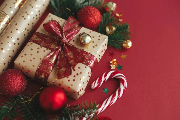 現代のクリスマスの構成 赤い背景にスタイリッシュなクリスマスギフト 包装紙 モミの枝 キャンディー杖と赤ちゃん メリークリスマスとハッピーホリデー 祭りの旗 — ストック写真