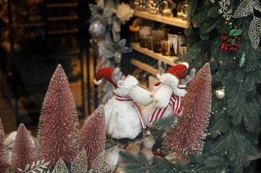 Şık noel pembe ağaçları, takı dalları ve ren geyiği oyuncakları mağazası, şenlikli bir mağaza. Şehir caddesinde modern noel dekorasyonu. Avrupa 'da kış tatili. Mutlu Noeller.